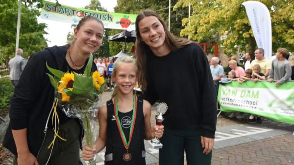 Hanneke en Emma Oosterwegel en een enthousiaste winnaar bij prijsuitreiking 25e appelloop